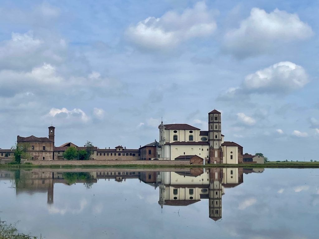 Risaia nel Vercellese con abbazia riflessa nell’acqua
